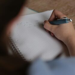 A focused student using the Pomodoro Technique with a small timer visible on their desk.