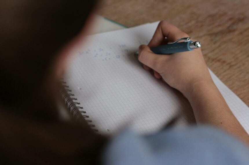 A focused student using the Pomodoro Technique with a small timer visible on their desk.