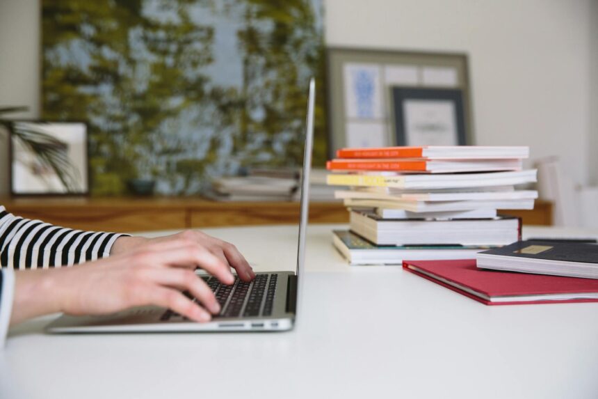 A diligent student sitting at a well-lit desk, surrounded by open textbooks and a laptop, focused on their studies.