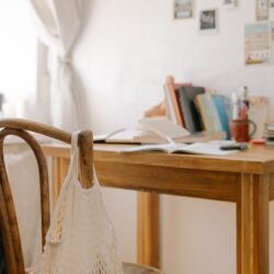 A high school student sits at their organized desk by a window, reviewing notes in the morning.