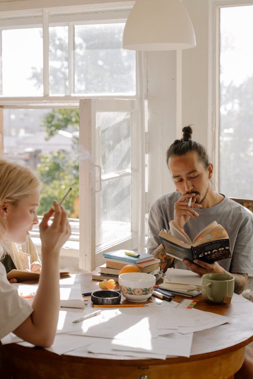 A university student smiling and stretching in a park after finishing an exam.