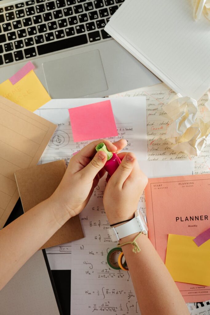An overhead view of a neat and organized student desk featuring a tablet, a planner, and a pen.