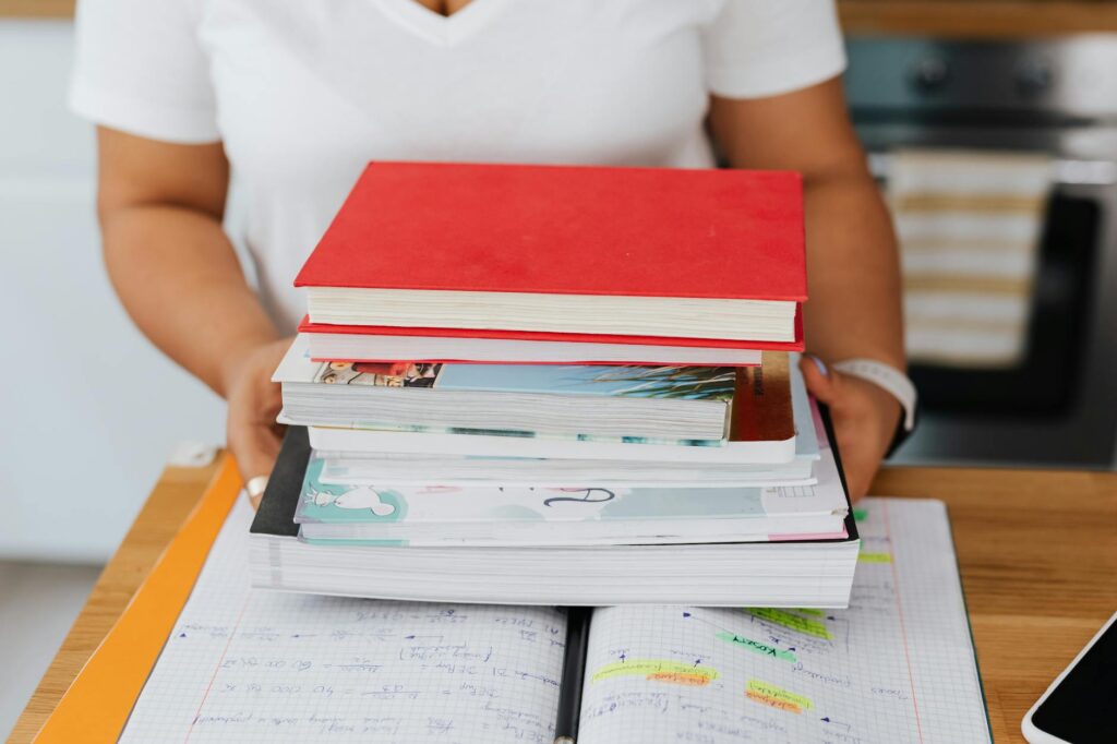 Close-up of a student's hands using a yellow highlighter on a weekly planner, marking out study times and deadlines.
