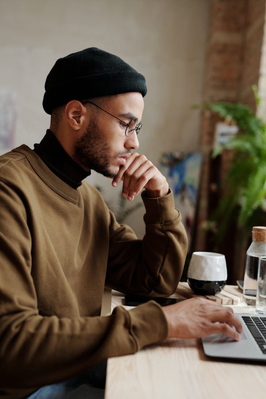 A focused student organizes their weekly schedule on a laptop next to a physical planner and a cup of coffee.