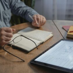 A college student sits at a desk, carefully reviewing their FAFSA and student loan award letter.