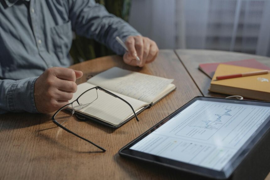 A college student sits at a desk, carefully reviewing their FAFSA and student loan award letter.