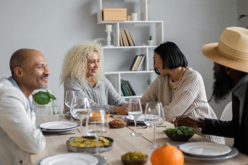 A diverse group of friends enjoying a lively potluck dinner in a warmly lit apartment.
