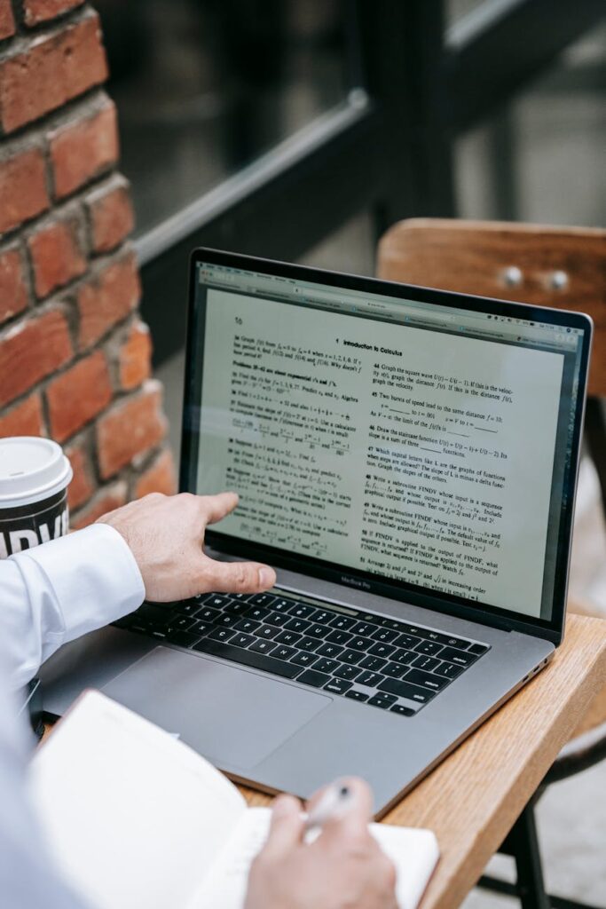 A creative student brainstorming and writing a scholarship essay in a journal.