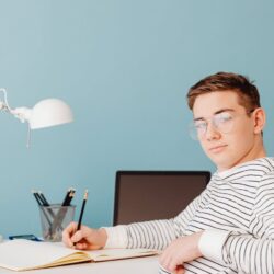 A focused college student carefully crafting their resume on a laptop in a well-lit study area.