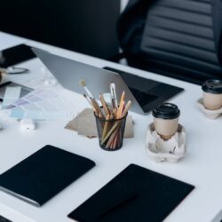 A neat and organized student's desk featuring an open laptop, a spiral notebook, and a cup of coffee.