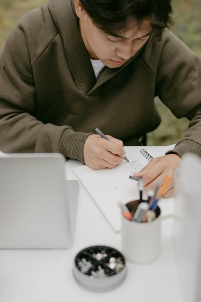 An organized and efficient study space, showing a laptop, notebook, and pens, representing smart study habits.