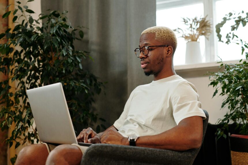 A graphic designer carefully curating their digital portfolio on a laptop.