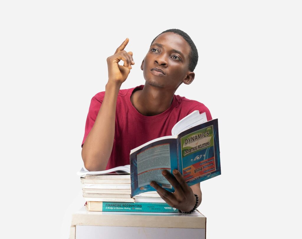 An overwhelmed student rests their head on a large pile of textbooks, symbolizing study burnout.