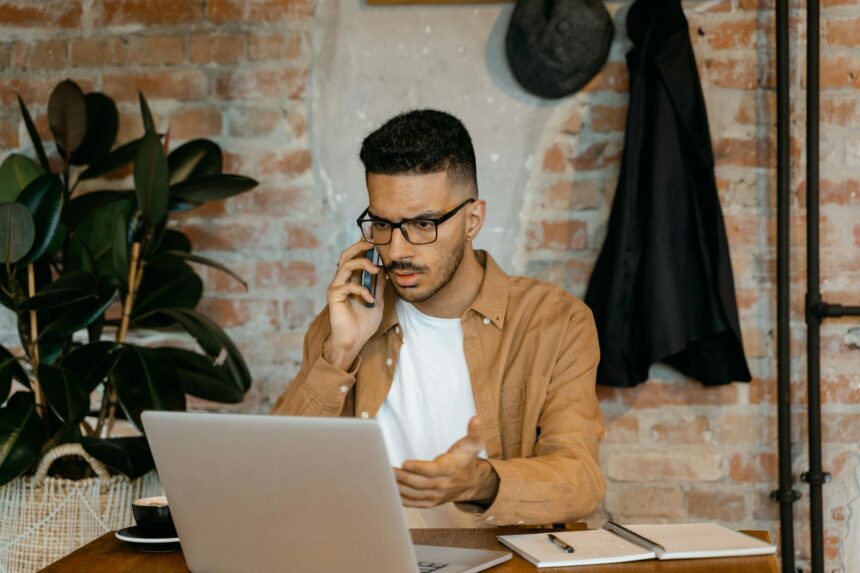 A young professional working on their laptop at a clean, modern desk in their home office.