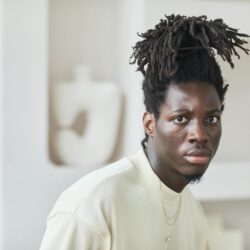 A young adult sitting at a desk, carefully reviewing their credit report on a laptop.