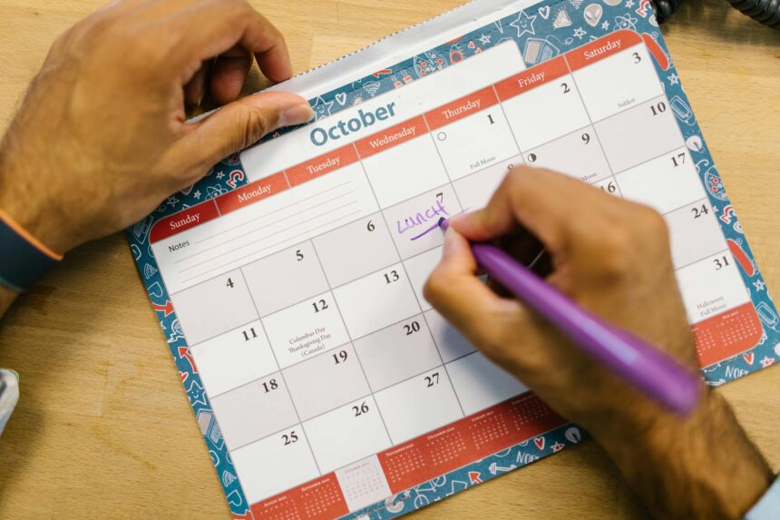 A university student diligently organizes their semester schedule using a physical planner and a digital calendar on their laptop.