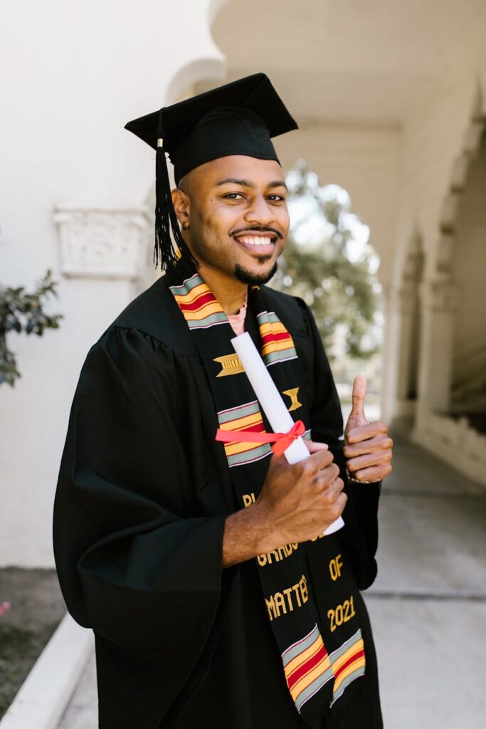 A joyful graduate in a cap and gown throws their cap into the sky on a sunny day, symbolizing freedom from debt.