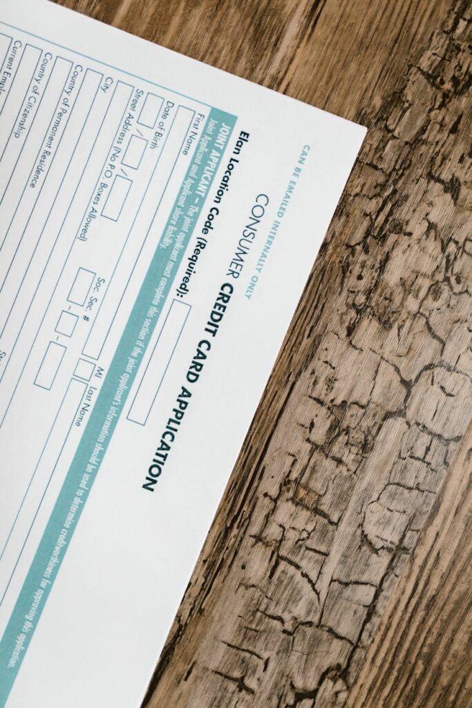 Close-up of a person's hands typing on a laptop, completing an online financial aid application form.