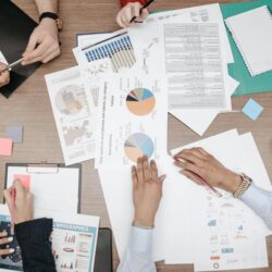 A diverse team of professionals analyzing financial data on a large screen in a modern office.