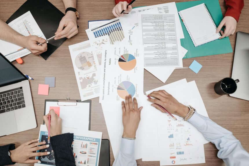 A diverse team of professionals analyzing financial data on a large screen in a modern office.