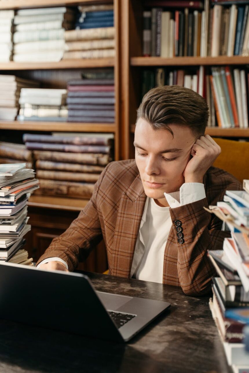 A focused college student sits at a desk, mapping out their career roadmap on a laptop and in a notebook.